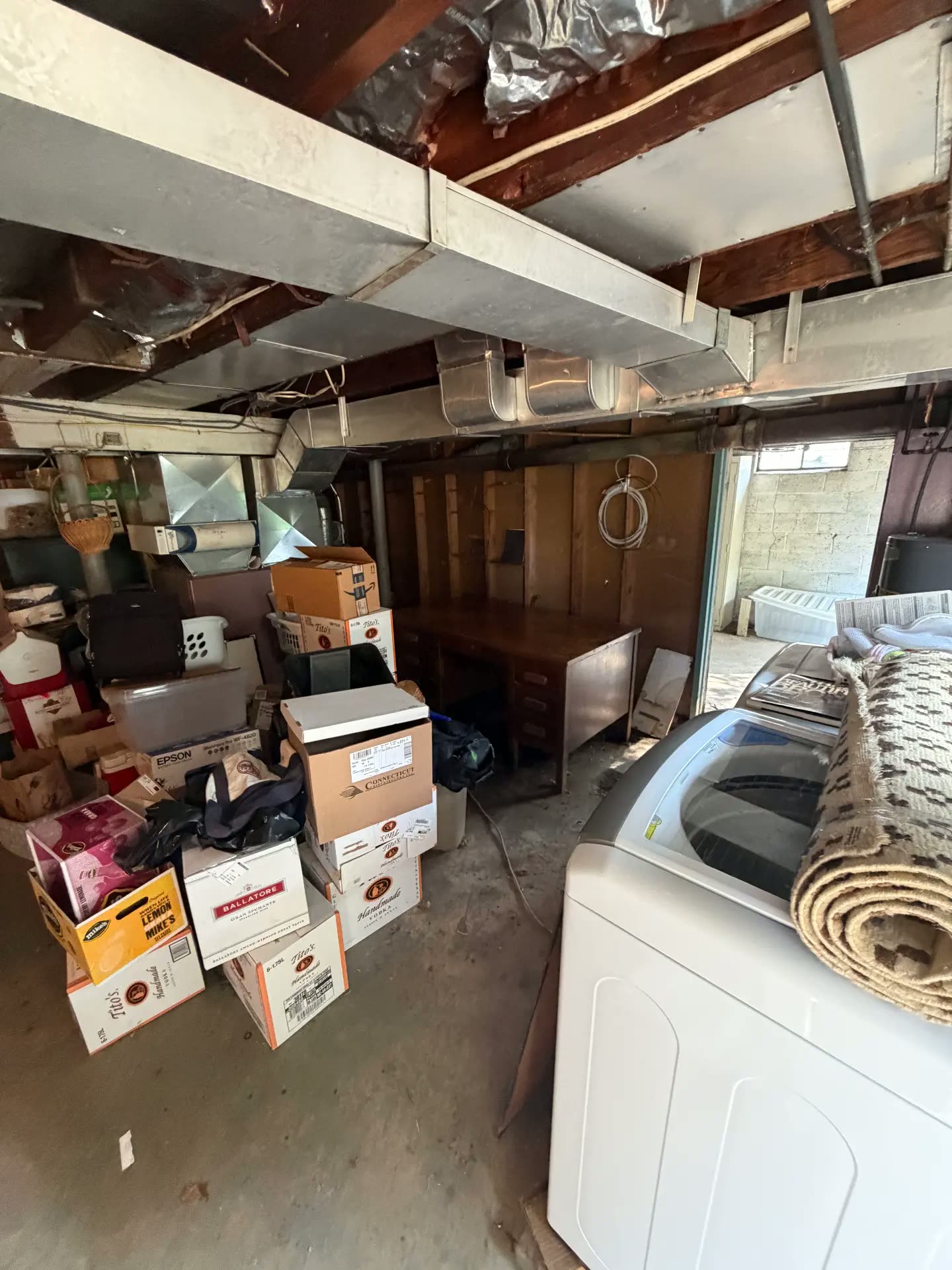 Basement laundry area buried in boxes before cleanout