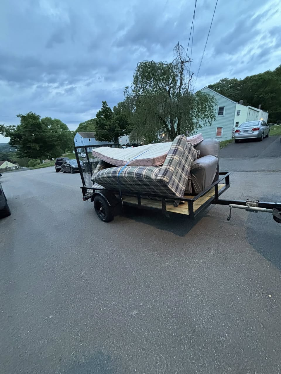 Trailer loaded with mattress and couch on CT road — furniture removal