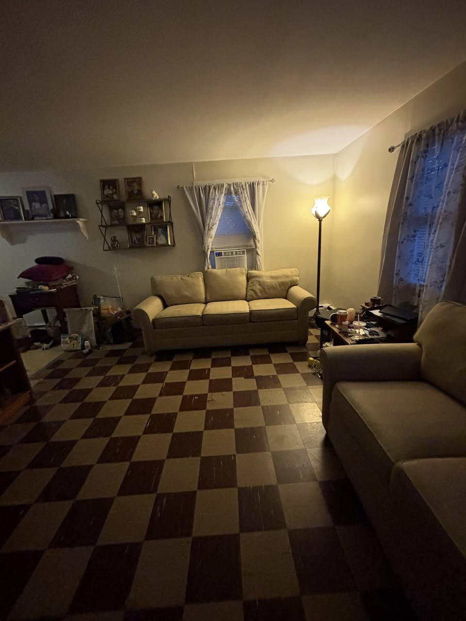 Living room before move-out cleanout — two couches on checkered floor